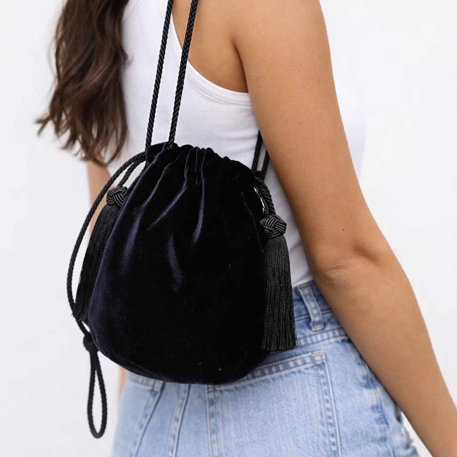 Matte Black Velvet Rounded Drawstring Bucket Pouch With Knotted Cord Side Tassel Accents And Continuous Twisted Woven Cord Shoulder Carry Strap