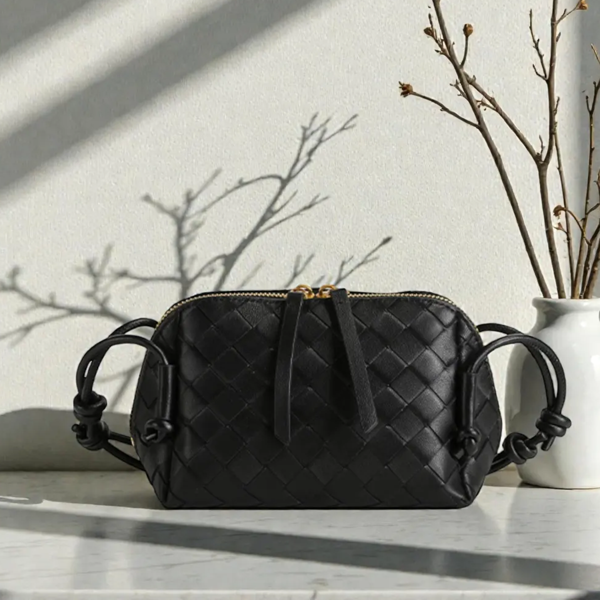 Multi-Tone Uniform Diamond Grid Woven Compact Rectangular Pouch With Knotted Side Loop Carry Strap And Dual Gold Pull Top Zipper Closure Hardware Leather Bag