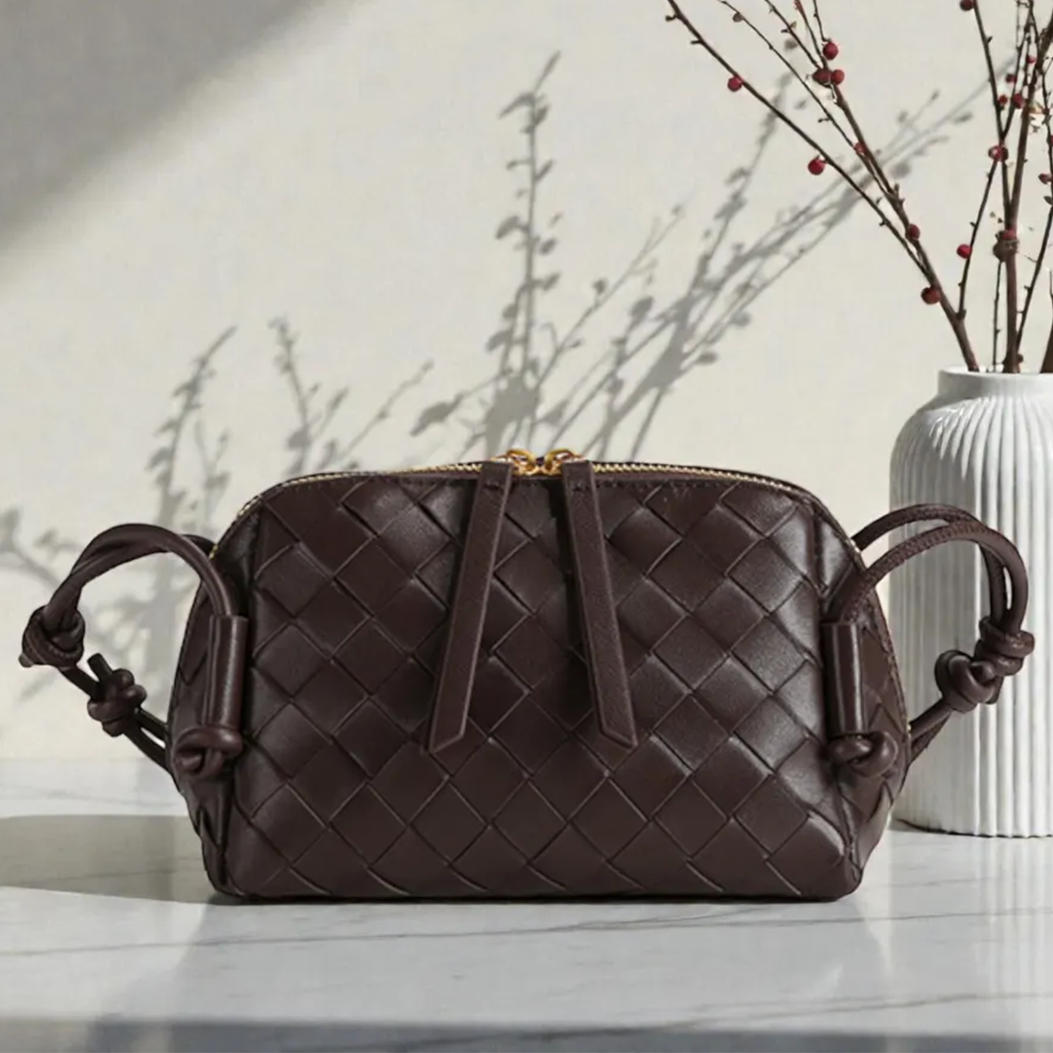 Multi-Tone Uniform Diamond Grid Woven Compact Rectangular Pouch With Knotted Side Loop Carry Strap And Dual Gold Pull Top Zipper Closure Hardware Leather Bag