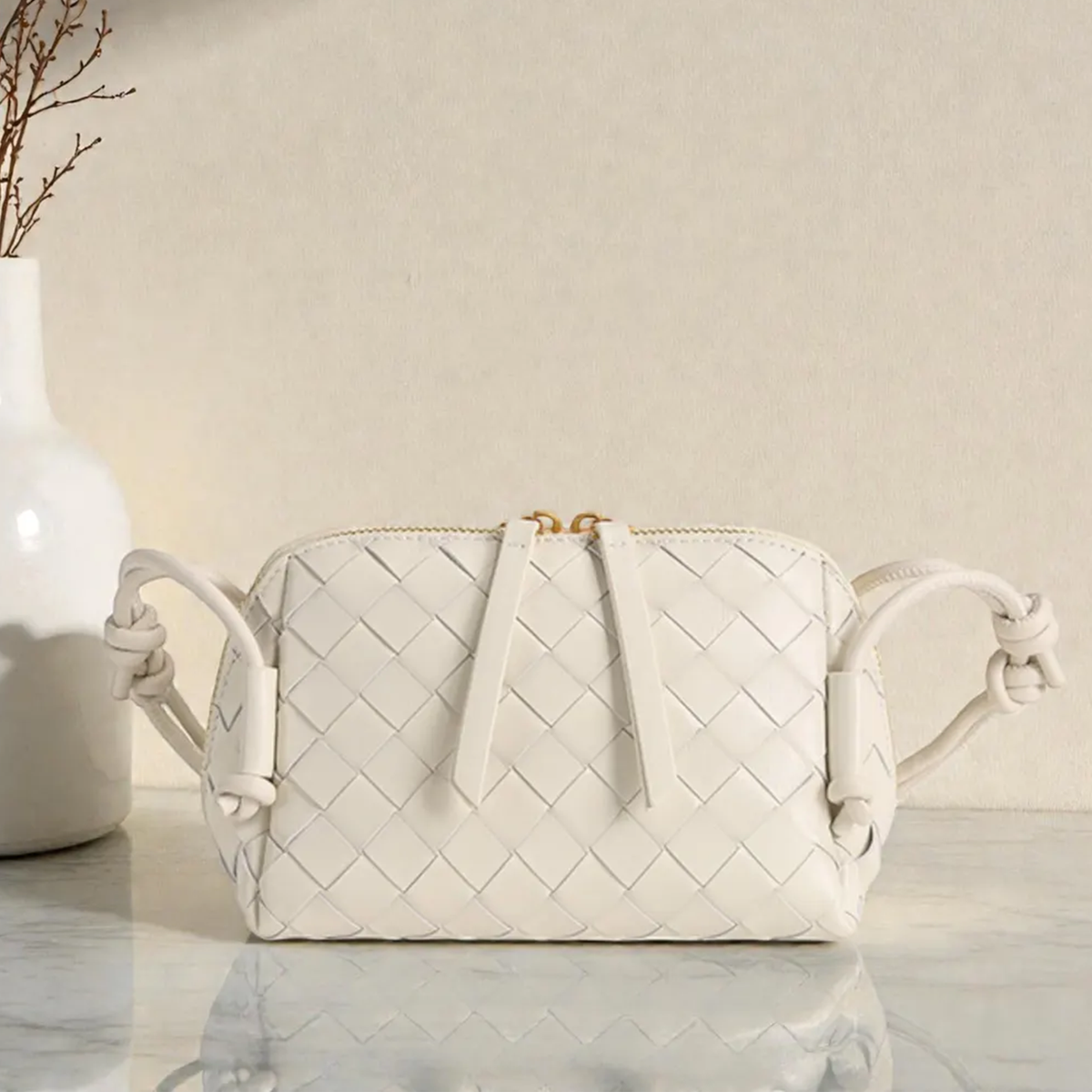 Multi-Tone Uniform Diamond Grid Woven Compact Rectangular Pouch With Knotted Side Loop Carry Strap And Dual Gold Pull Top Zipper Closure Hardware Leather Bag