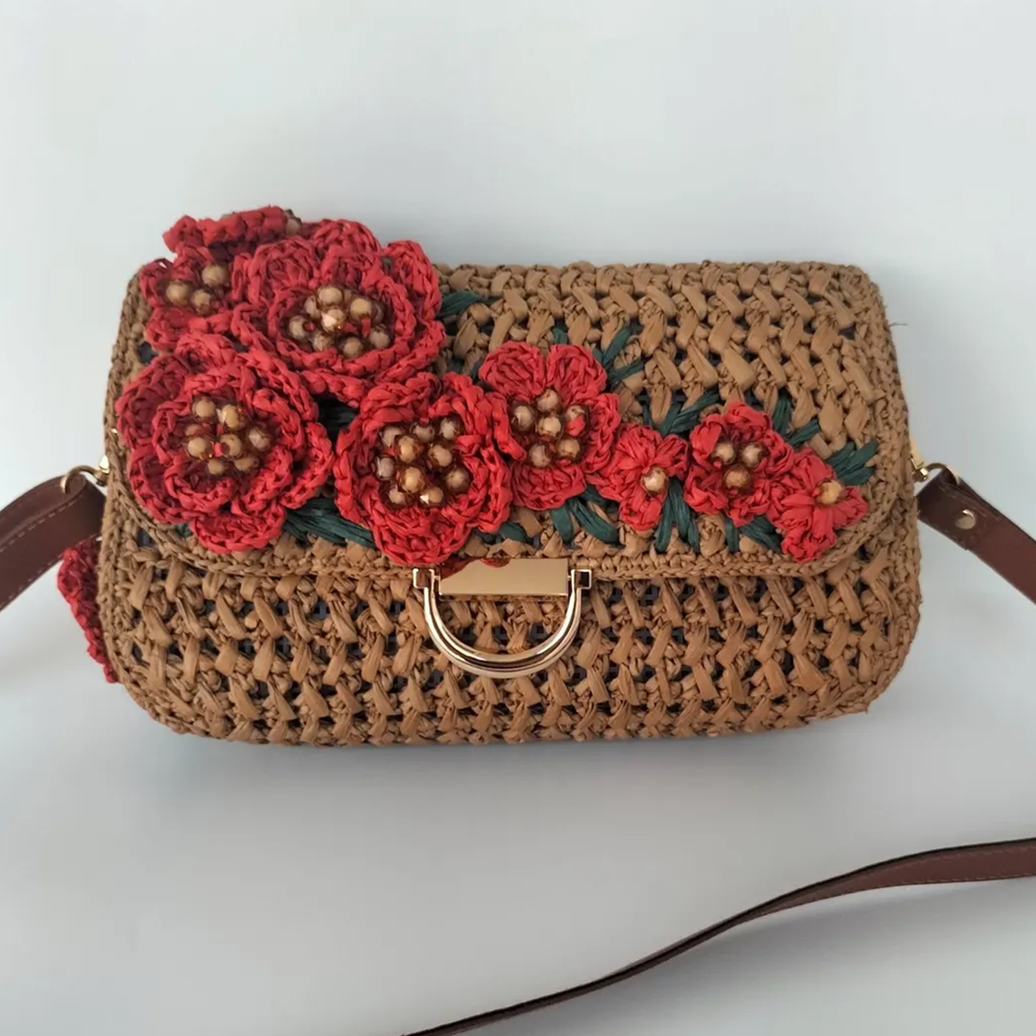 Warm Tan Open Grid Woven Straw Rectangular Satchel With Hand Crochet Red Floral Flap Embellishment, Polished Golden D-Ring Clasp And Fixed Brown Trim Shoulder Strap Hardware